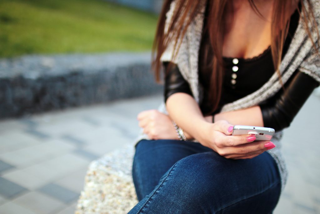 mujer recibiendo sms código corto